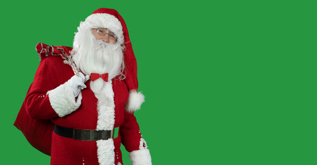santa claus on a green background with a large red bag stands looking at the camera. Copy space. Christmas and New Year concept