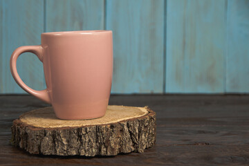 A pink cup on a wooden stump
