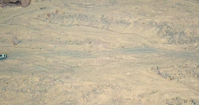 Aerial Over Off Road 4x4 Car Driving Along Gravel Trail Path.Overhead On White Offroad Vehicle On Desert In Safari Trip To Wishwashi Colored Canyon - Ras Shaitan Nuweiba Dahab,Egypt.4k Drone Flight.