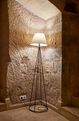 Floor lamp in front of stone wall