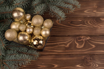 Stylish bucket of Christmas Golden toys on a white wooden background and branches of Christmas trees