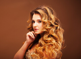 Fototapeta premium Beaity and fashion concept: Blond woman with long, healthy and shiny curly hair . Beautiful model woman with wavy hairstyle .Care and beauty.