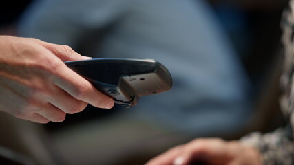 Closeup businesswoman hands paying with mobile phone over pos terminal