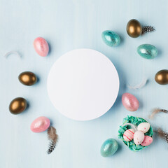Fototapeta na wymiar Easter greeting card with colorful easter eggs on blue background. Top view, flat lay with space for your text.