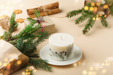 Trendy handmade soy candle, natural decorations, gingerbread cookies on beige background. Christmas zero waste eco friendly gift concept.