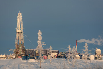 Winter landscape of a taiga forest with a drilling rig at the Northern oil and gas field....