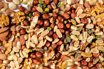 Nuts background. A mix of peanuts, hazelnuts, walnuts, pistachios and almonds, shot from the top