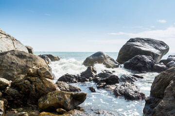 Fototapeta na wymiar Seascape of waves splashing the stones in the rocky coastline of Yangxi, Yangjiang of China