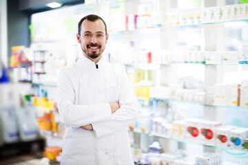 Fototapeta na wymiar Cheerful pharmacist showing assortment of drugs in pharmacy