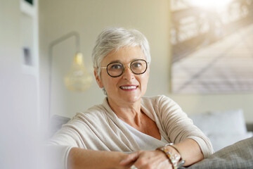 portrait of a beautiful smiling 55 year old woman with white hair