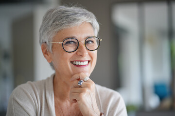 Portrait of a attractive smiling 55-year-old woman with white hair