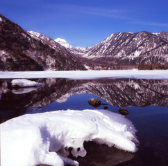 冬の湯ノ湖の風景と湖面に映りこんだ水鏡の風景