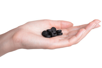 Activated carbon pills on a female hand