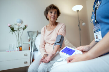 Home Nurse Checking Blood Pressure of Female Senior Patient With Focus on Blood Pressure Machine....