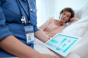 Digital Tablet Showing Test Results of Elderly Female Patient Lying in Bed in the Background....
