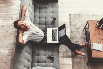 smiling young man is talking on his smartphone .