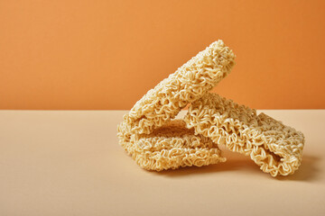 three blocks of dry instant noodles on a brown and beige background