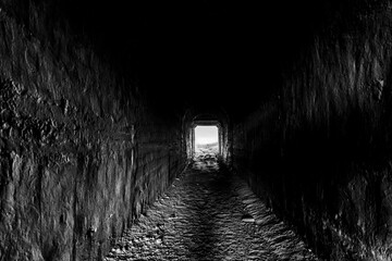 Light at the end of the tunnel. Monochrome photo with grainy effect