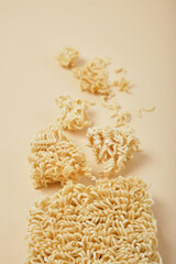 block instant noodles on a beige background top view copy space, noodle pieces