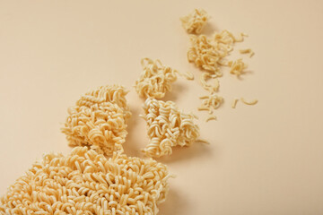 block instant noodles on a beige background top view copy space, noodle pieces