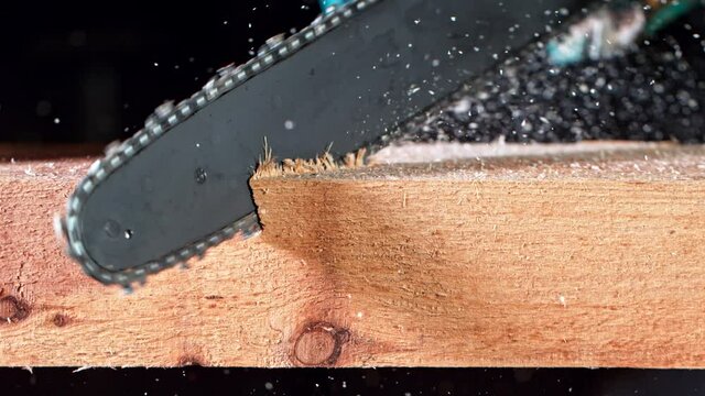 Super Slow Motion Detail Shot of Cutting Wood with Chainsaw at 1000 fps.