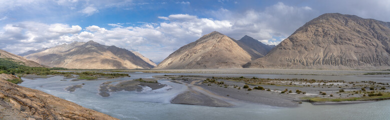 Panoramic view of Panj river valley in Wakhan Corridor with Hindu Kush mountain range in Afghanistan at Langar, Gorno-Badakshan,  Tajikistan Pamir