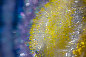 Abstract festive bright colorful background of Christmas garlands with bokeh. Blank for the designer. Blurred. The predominance of blue, yellow and silver colors.