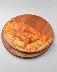 Calzone pizza, closed pizza on a wooden board over white background. Trditional Italian calzone pizza isolated on white.