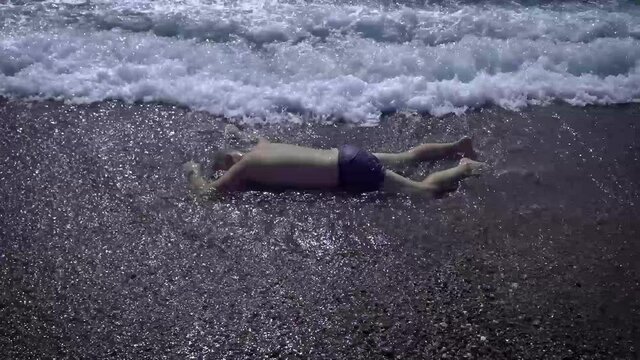 The body of a man washed up on the beach. A drowned man in swimming trunks who was neglected by safety rules on the water.