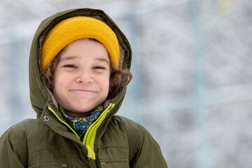 Portrait of smiling cute 8-year-old boy in winter clothes.