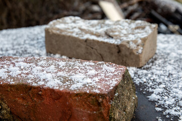 Snowy old bricks. Construction season and weather conditions. Cold and work safety