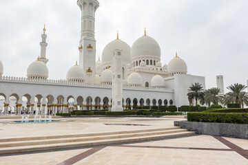 Fototapeta na wymiar White Grand Mosque built with marble stone against blue sky, also called Sheikh Zayed Grand Mosque in Abu Dhabi, UAE
