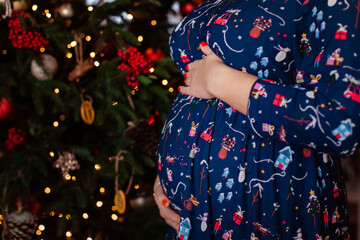 Pregnant girl on the background of the Christmas tree