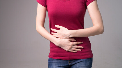 Young beautiful woman having painful stomachache on white background.Chronic gastritis. Abdomen bloating concept.