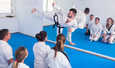Young male instructor demonstrates his skills in martial arts in the room