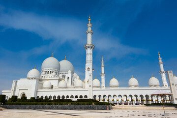 Fototapeta na wymiar White Grand Mosque built with marble stone against blue sky, also called Sheikh Zayed Grand Mosque in Abu Dhabi, UAE