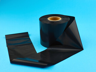 Thermal transfer ribbon. Production of labels using thermal printing technology. Thermal transfer tape on a blue background