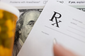 Dollar bill and doctors prescription are on doctors table in clinic closeup. Corruption among...