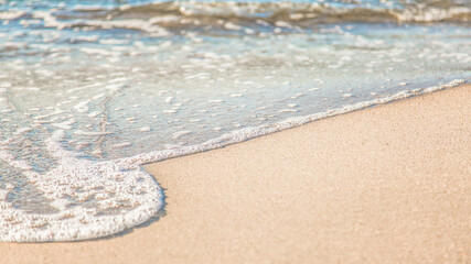 the waves of the sea on the sandy beach on a sunny day