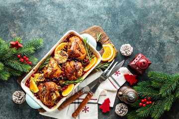 Christmas turkey legs baked with cranberries, orange and rosemary. Delicious festive dish for Christmas time. Top view,  christmas food background with space for a text - 394596436