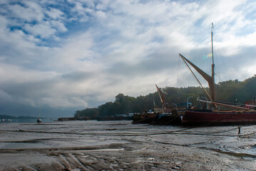 Boats stranded by low tide on the River Orwell at Pin Mill, Suffolk, UK
