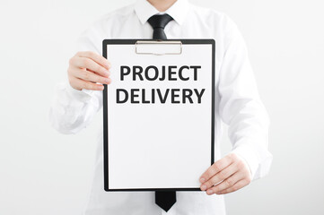 PROJECT DELIVERY is written on white paper held by a man.