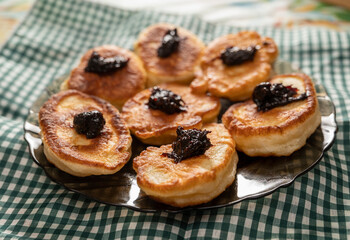 Pancakes or fritters with jam in plate on a table