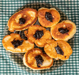 Pancakes or fritters with jam in plate on a table
