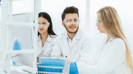 close up.a team of scientists sitting at the laboratory table