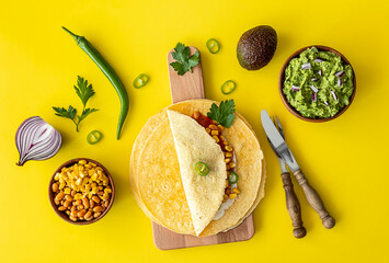 Tortilla wrap or burrito with corn, beans, greens, and homemade guacamole.
