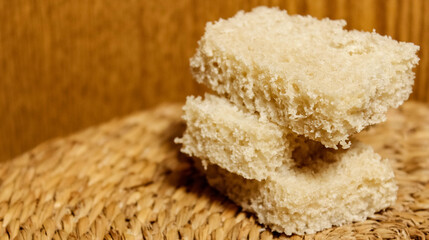 Slices of fresh gray bread on a wooden background.