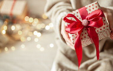 Beautifully wrapped christmas gift close up on blurred background with bokeh copy space.