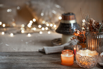 Cozy winter background with details of home decor on a blurred background with lights copy space.
