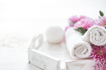 Spa composition with body care products and pink flowers.